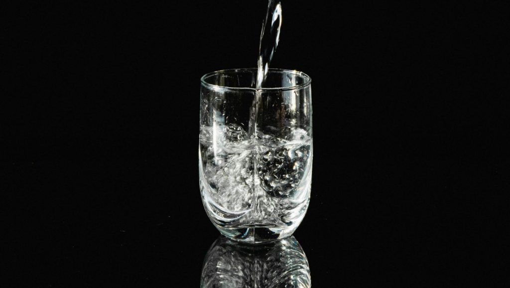 a glass filled with water sitting on top of a table