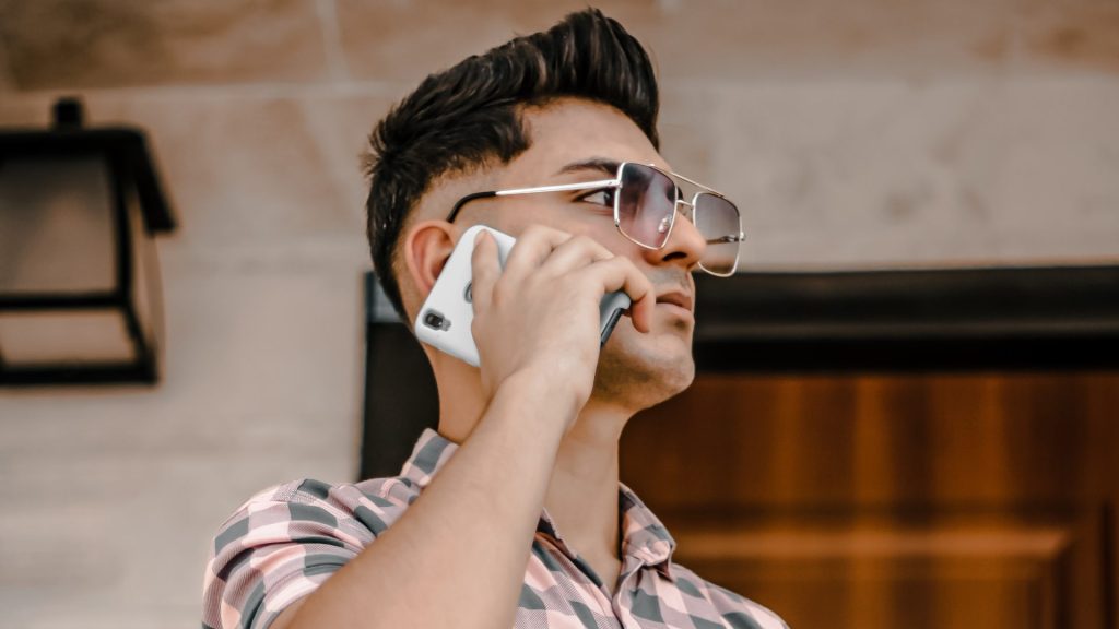 a man wearing glasses talking on a cell phone