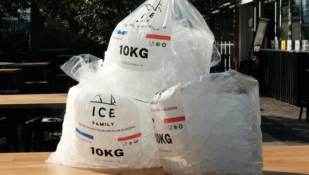 Bags of ice sitting on top of a barrel
